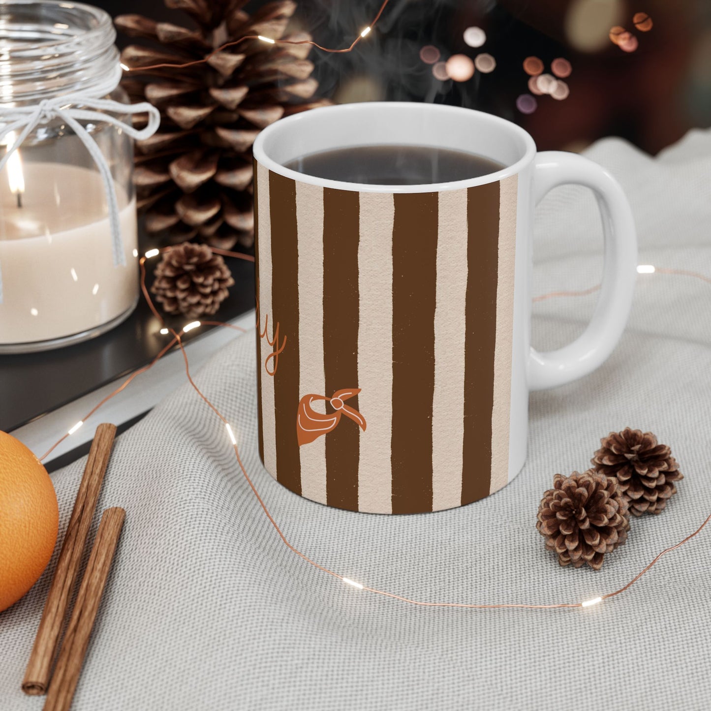 Striped mug with autumn-themed decorations on a table