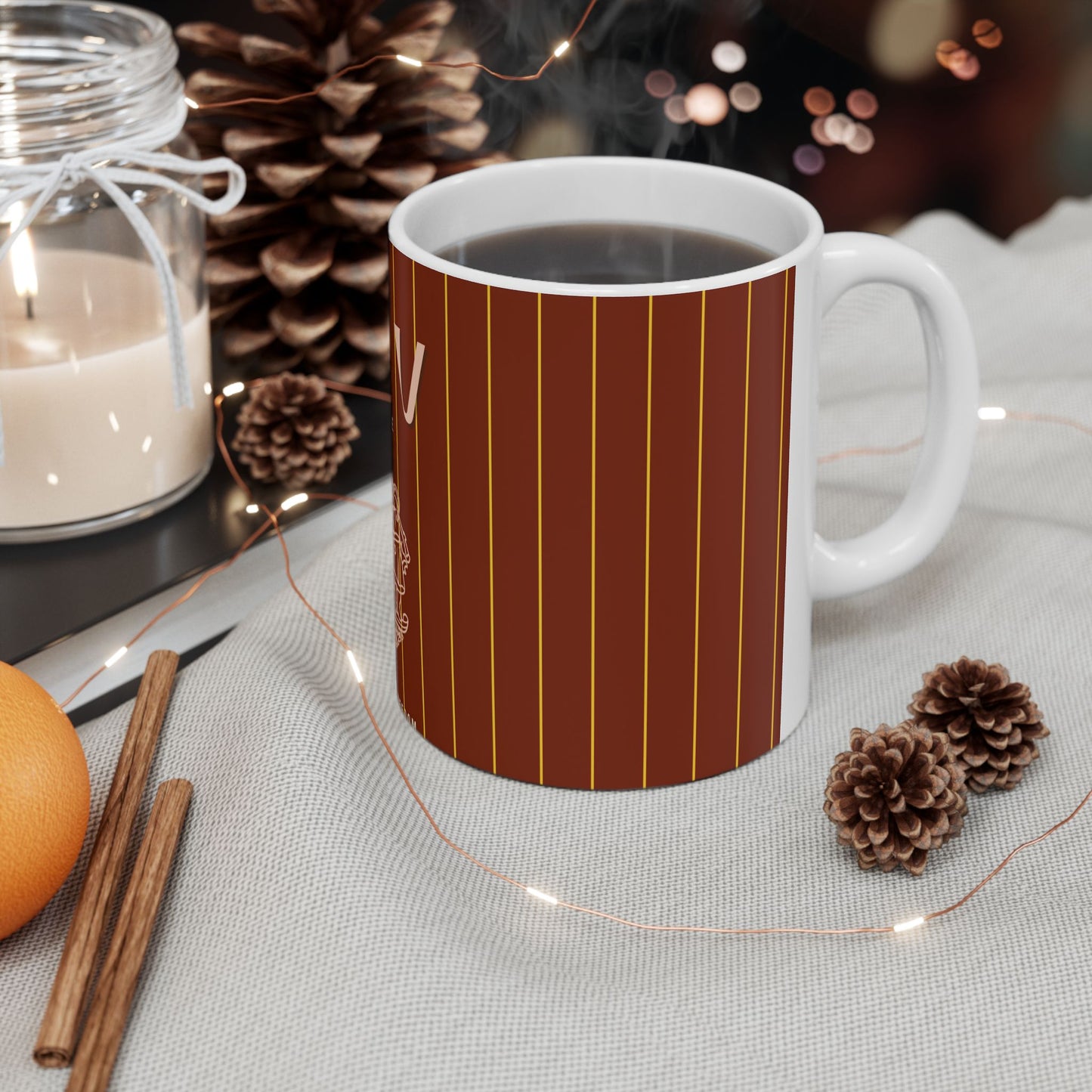 White mug with brown striped pattern on a table with decorative items