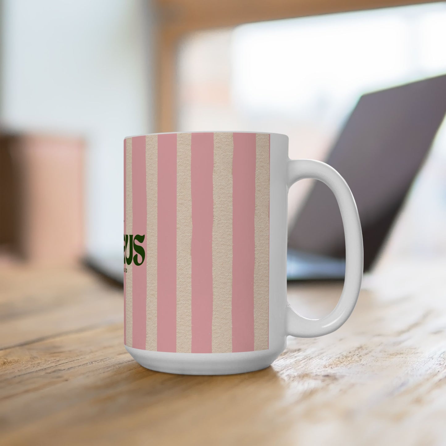 White mug with pink and beige striped pattern on a wooden surface