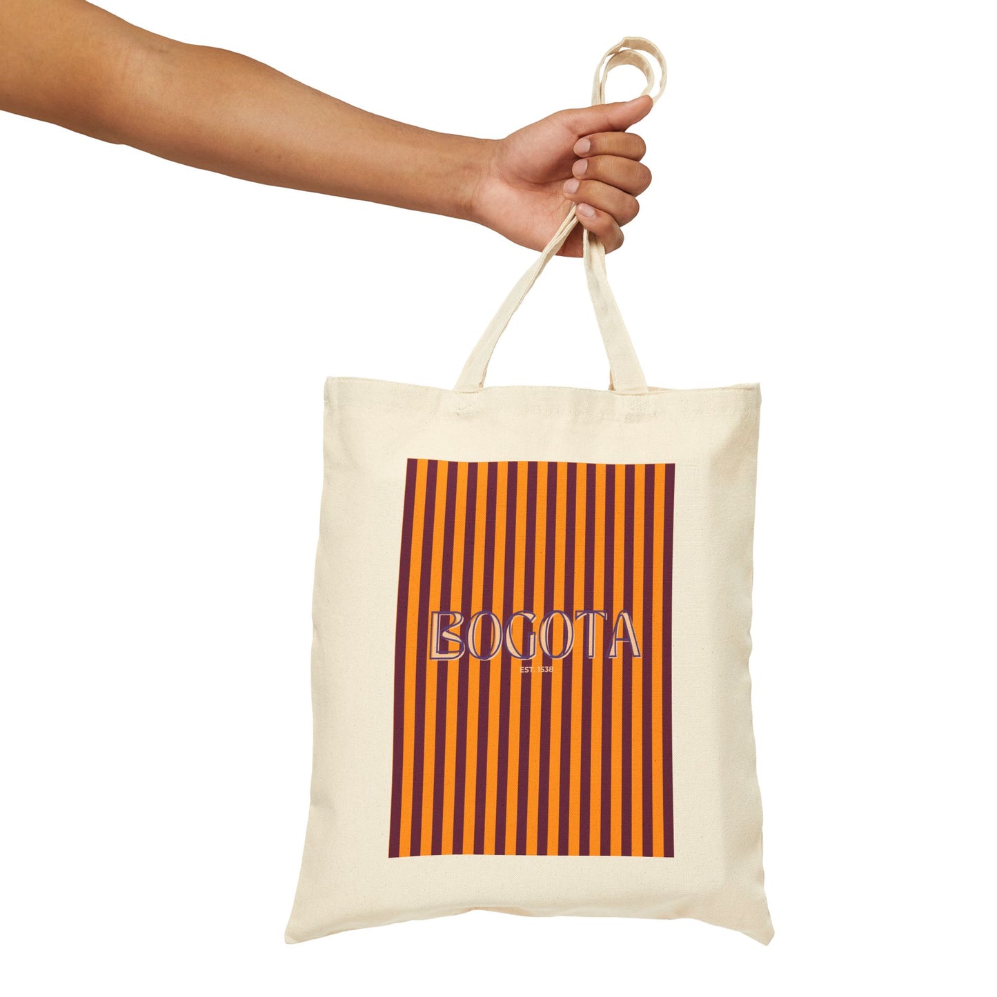Tote bag with striped design and 'BOGOTA' text held by a hand on a white background