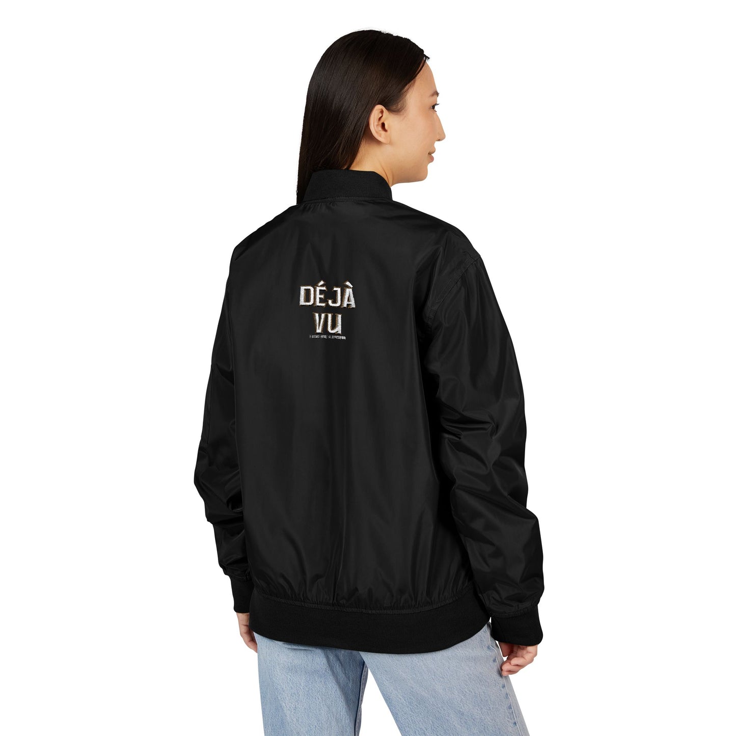Person wearing a black bomber jacket with 'DEJA VU' text on the back, sutainable fashion