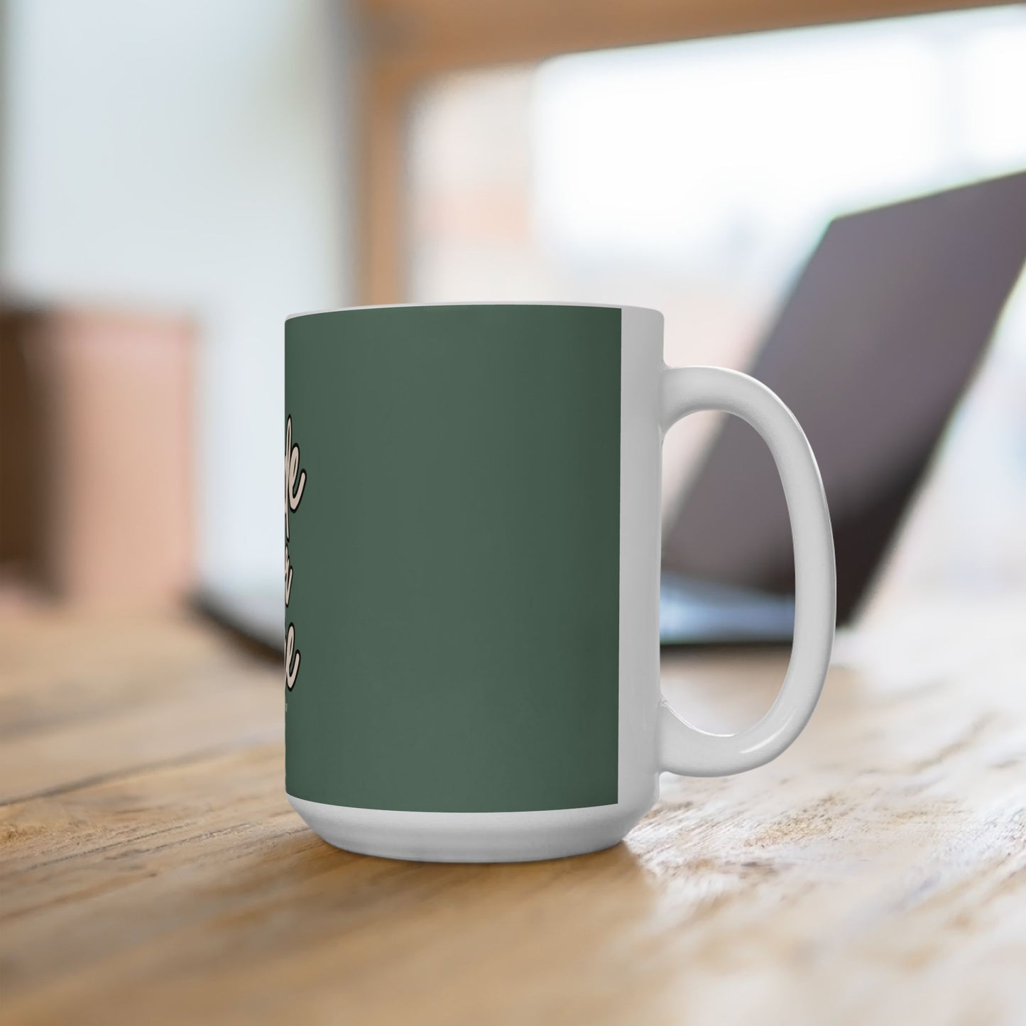 Green mug with white handle on a wooden surface