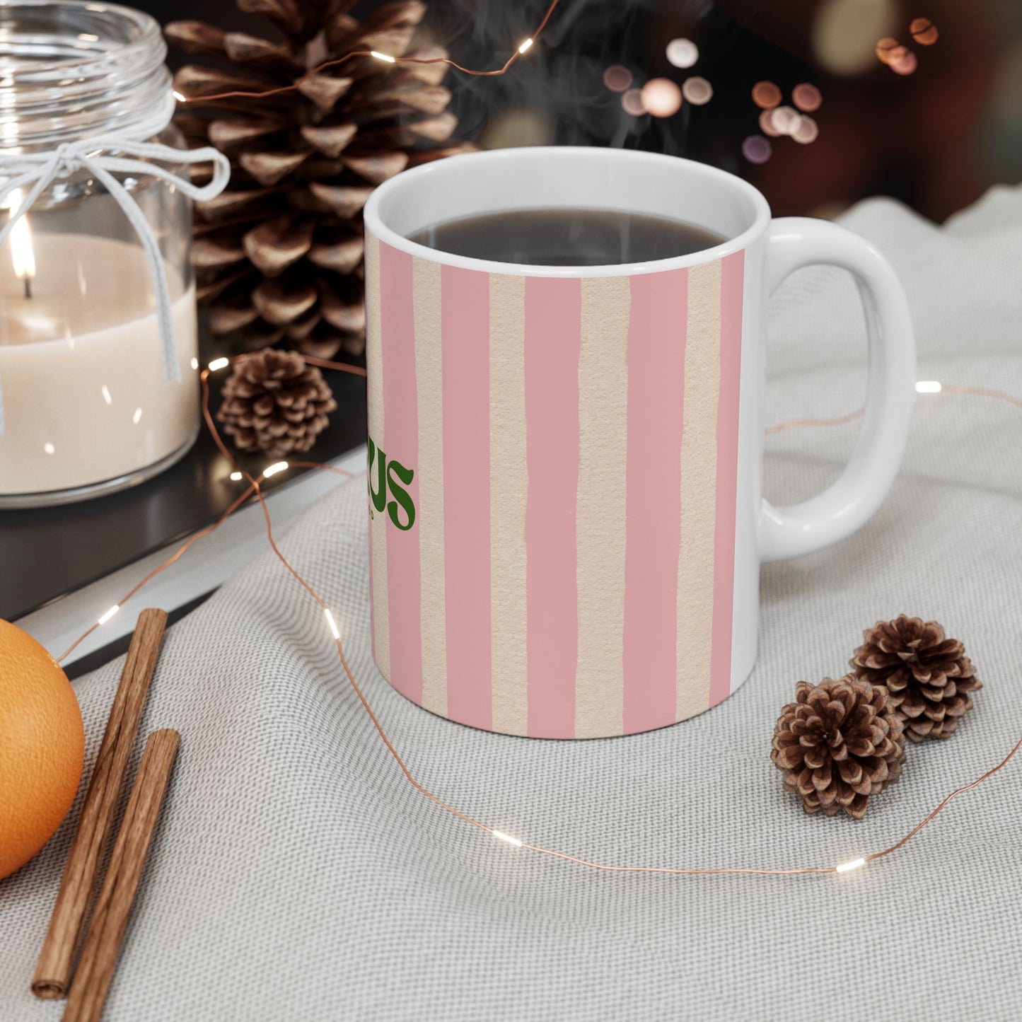 Striped mug with a brand logo on a table with decorative items
