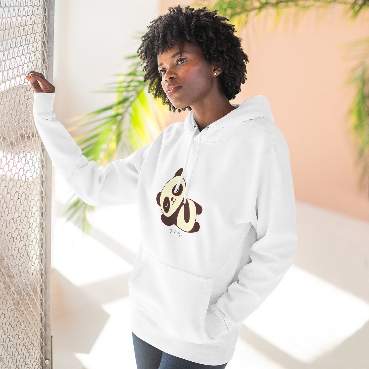 Person wearing a white hoodie with a panda design, standing against a light background.