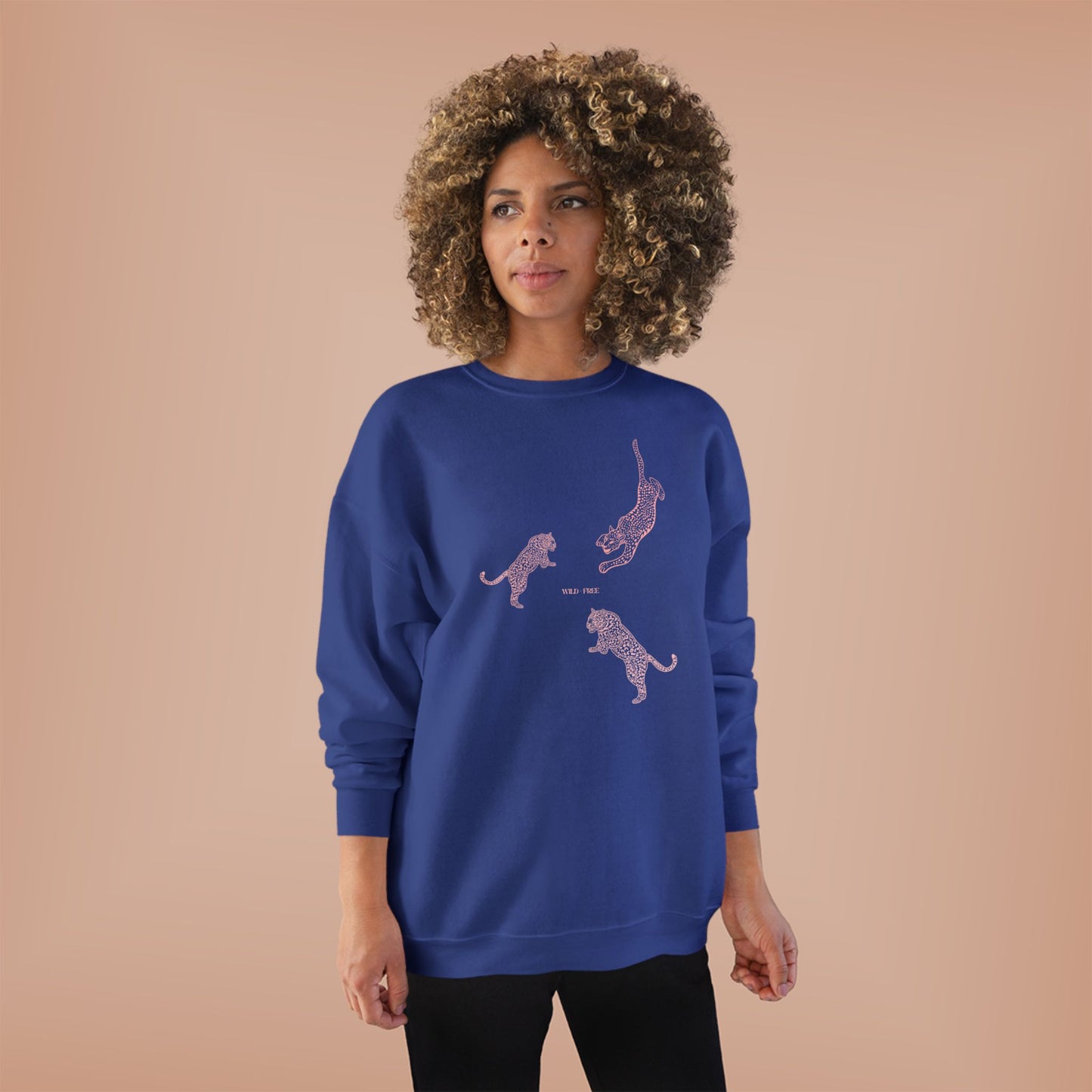 Woman wearing a blue sweatshirt with cheetah designs on a beige background