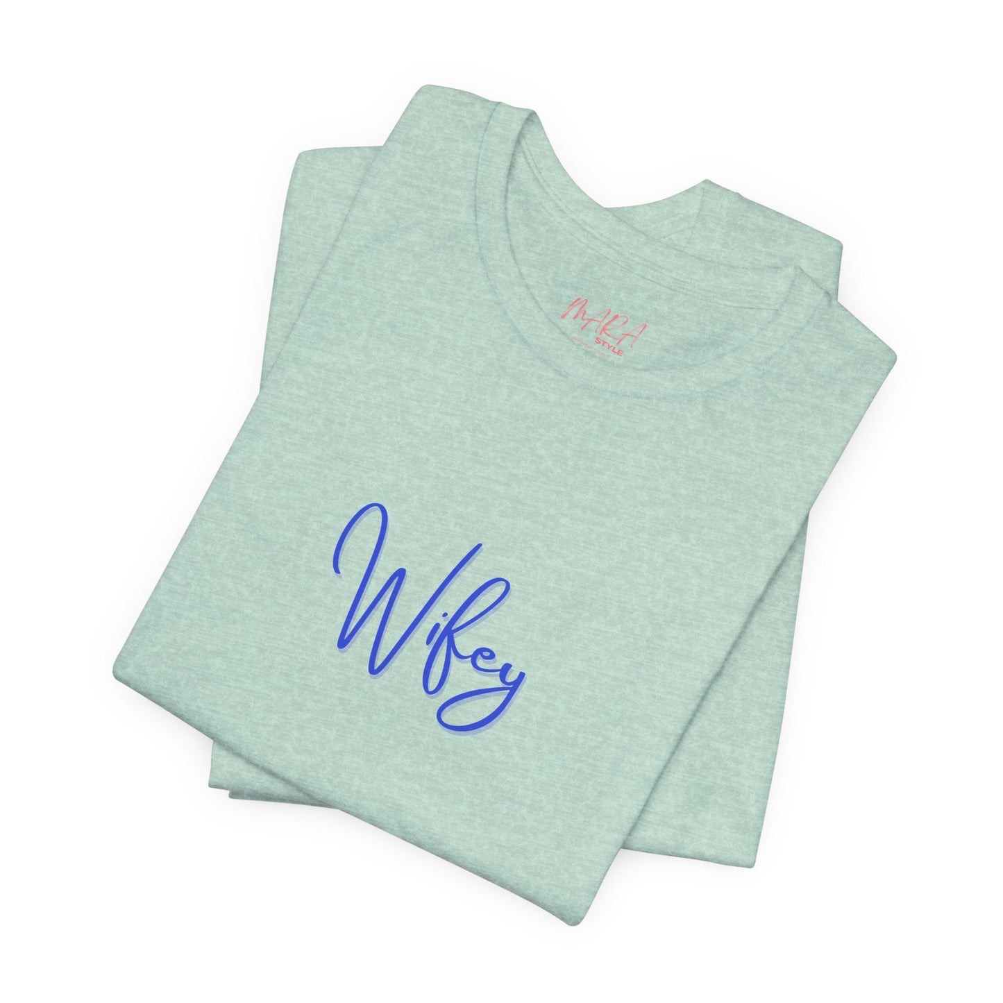 Folded light green t-shirt with 'Wifey' in blue on a white background