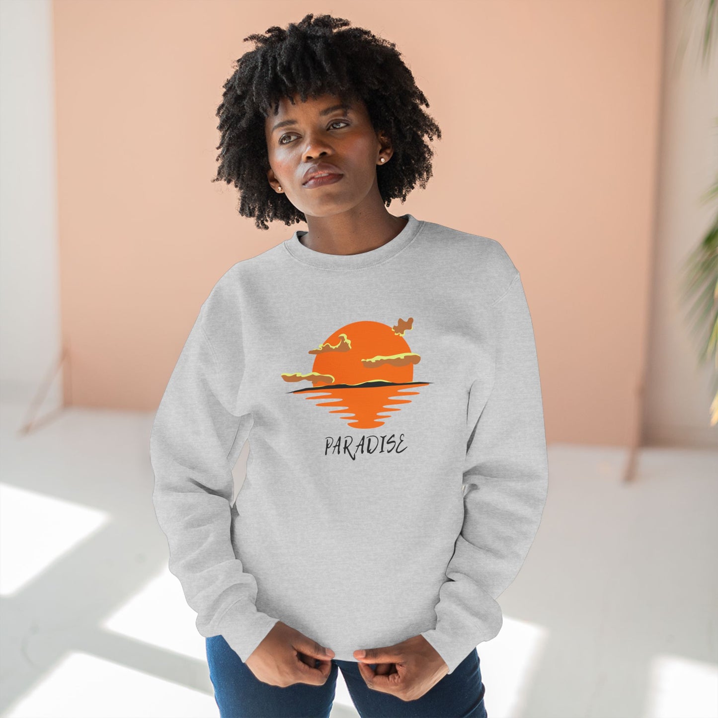 Person wearing a gray sweatshirt with a sunset design and 'Paradise' text.