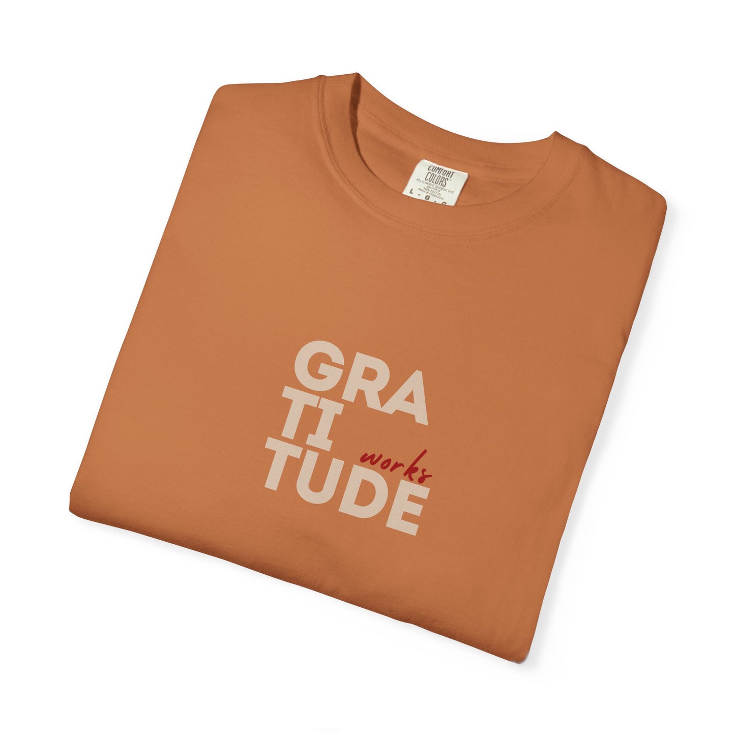 Folded brown t-shirt with 'GRATITUDE' text on a white background