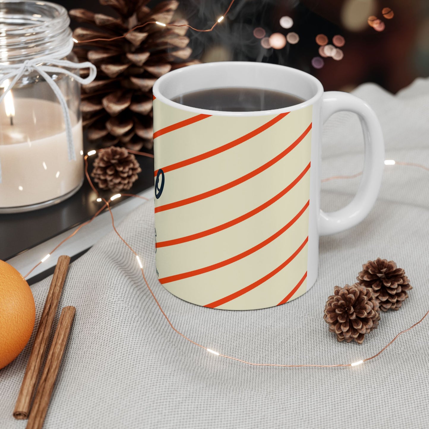 White mug with red stripes on a table with decorative items