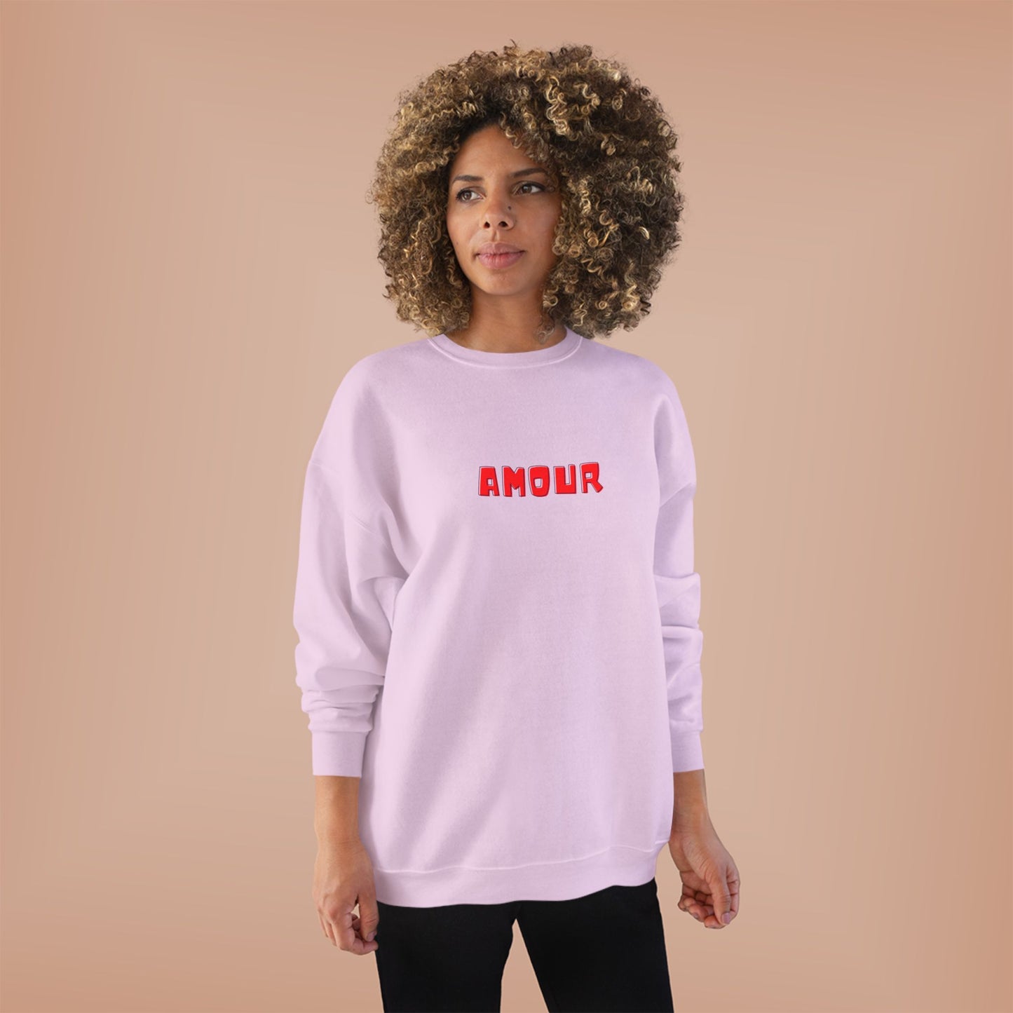 Person wearing a pink sweatshirt with 'AMOUR' printed in red on a beige background