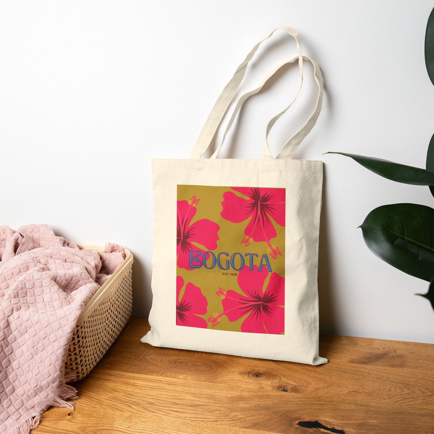 Tote bag with pink floral design and 'Bogota' text on a wooden surface.