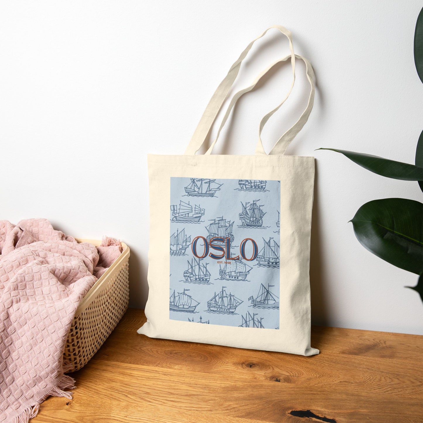 Tote bag with 'Oslo' design on a wooden surface with a plant in the background