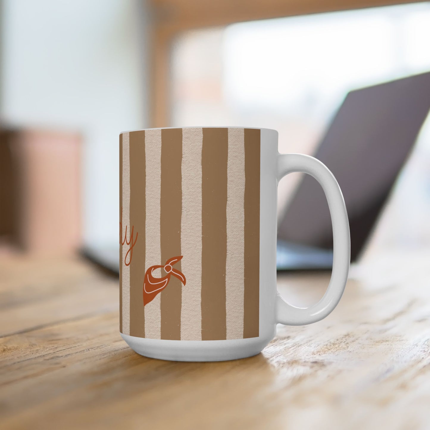 White mug with brown striped pattern and logo on a wooden surface