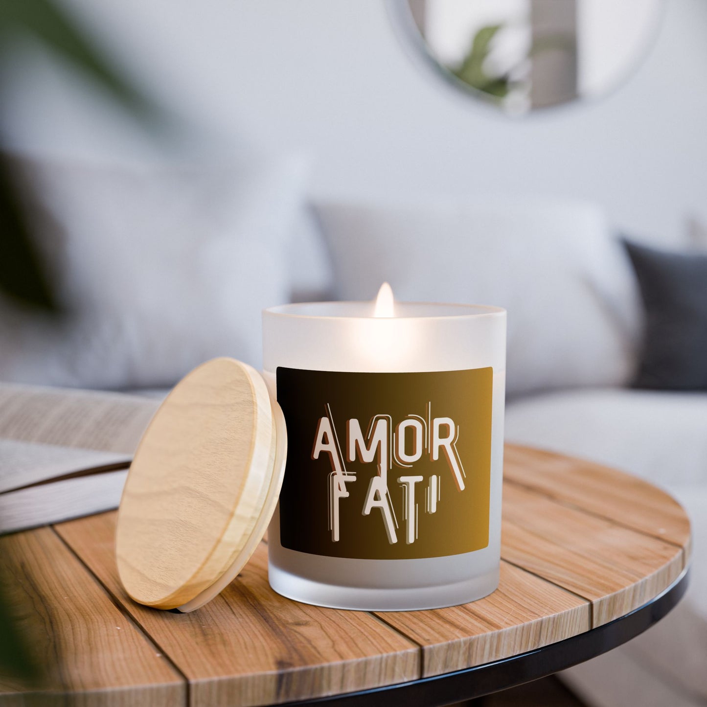 Candle with 'AMOR FATI' on a wooden table with a blurred background