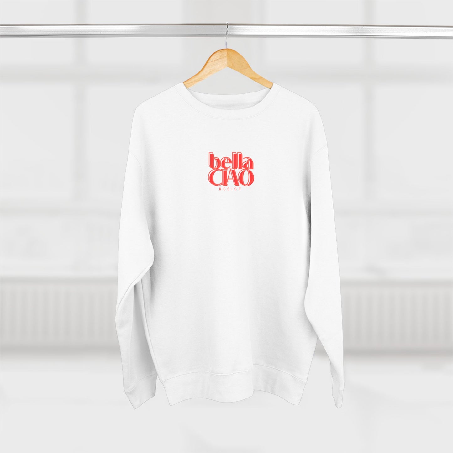 White sweatshirt with 'bella CHA0' text on a wooden hanger against a white background