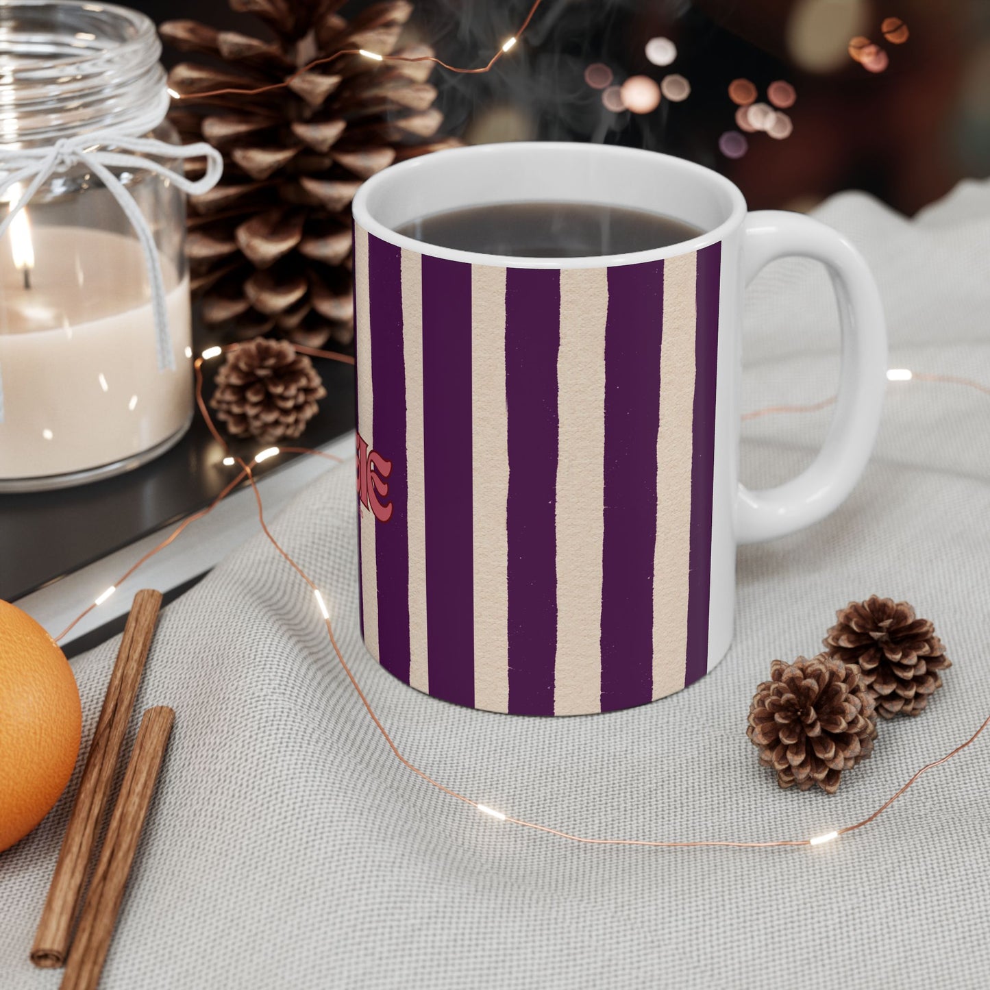 Striped mug with purple and beige pattern on a table with decorative items
