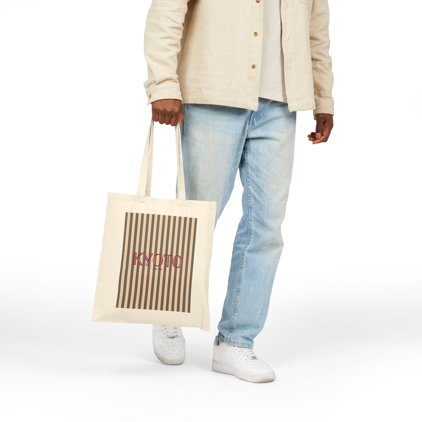 Person holding a tote bag with 'Kyoto' print on a white background