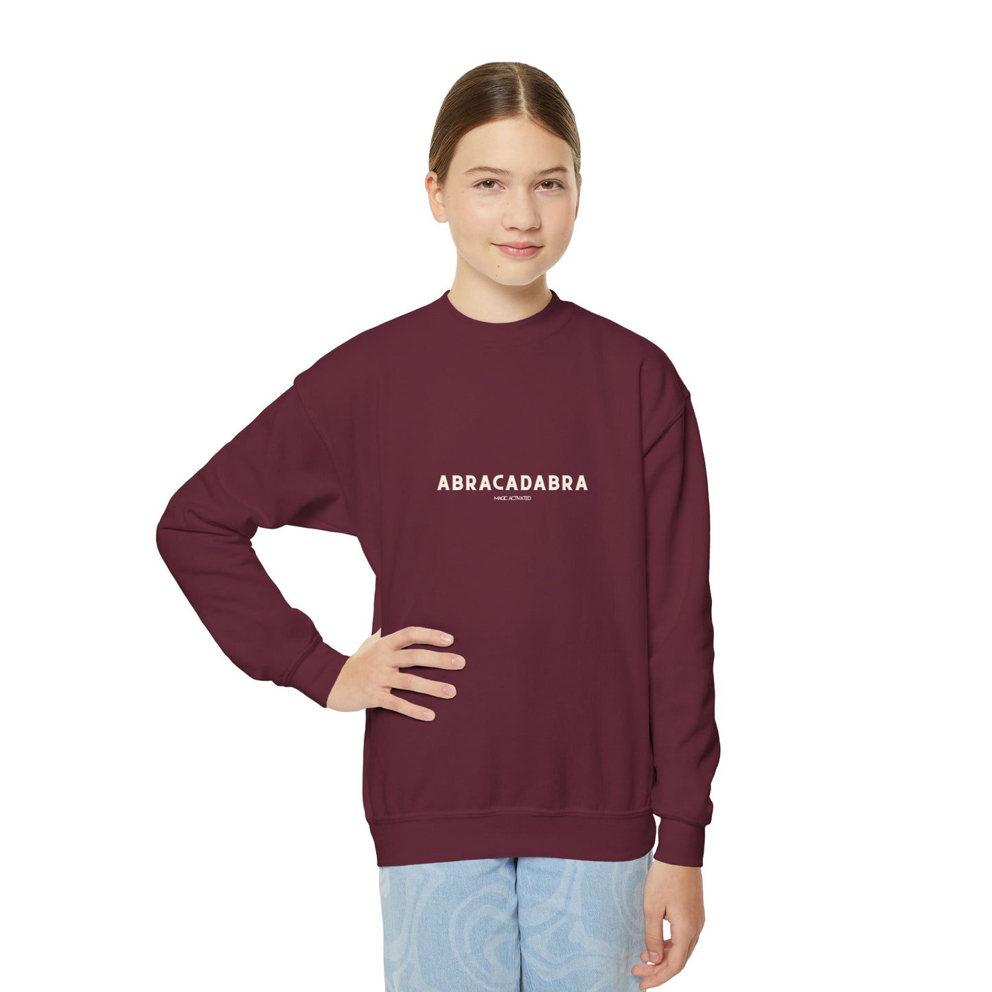 Person wearing a maroon sweatshirt with 'ABRACADABRA' text on a white background