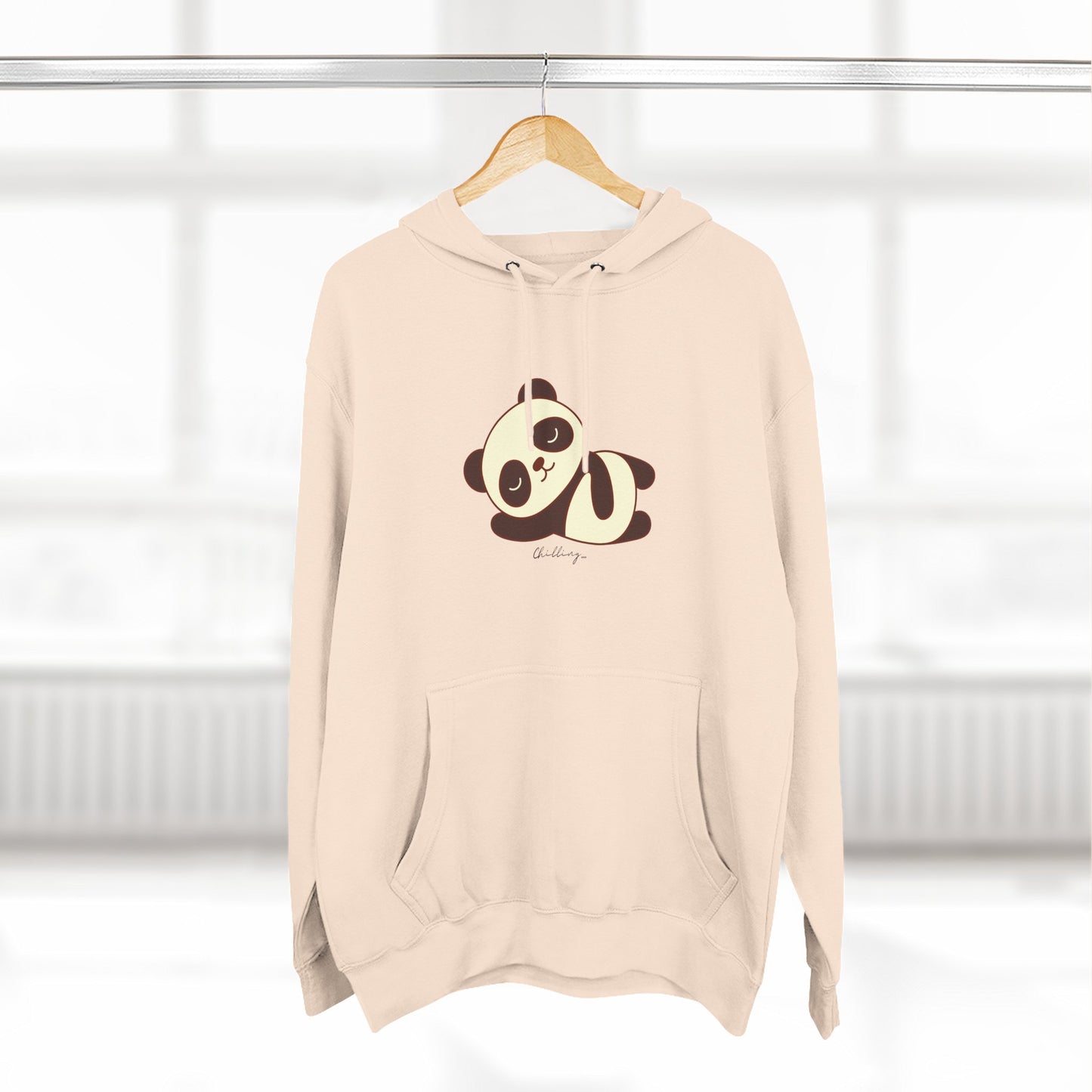 Beige hoodie with panda design on a hanger against a white background