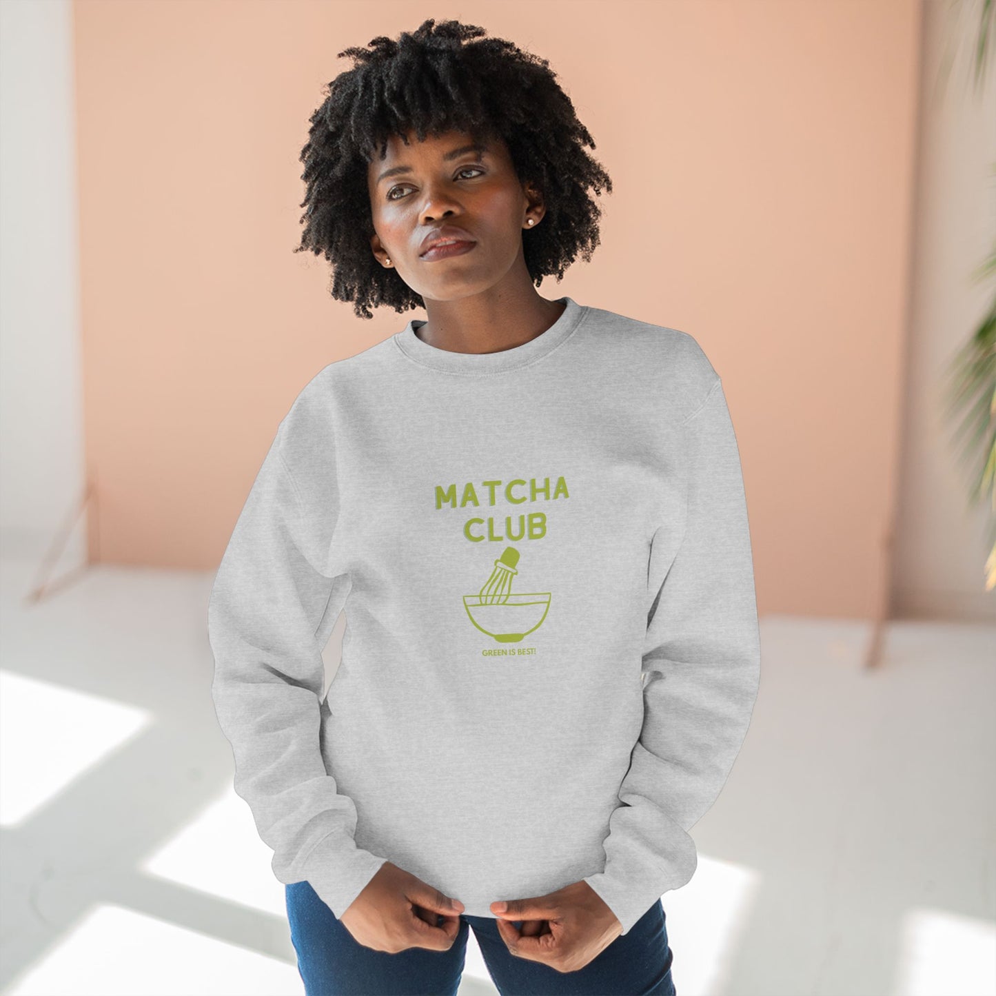 Person wearing a gray sweatshirt with 'Matcha Club' text and logo indoors.