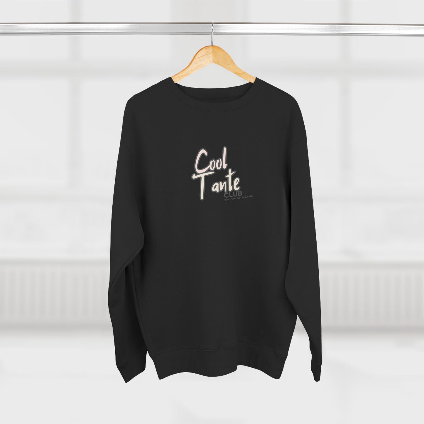 Black sweater with 'Cool Tante' text on a wooden hanger against a white background