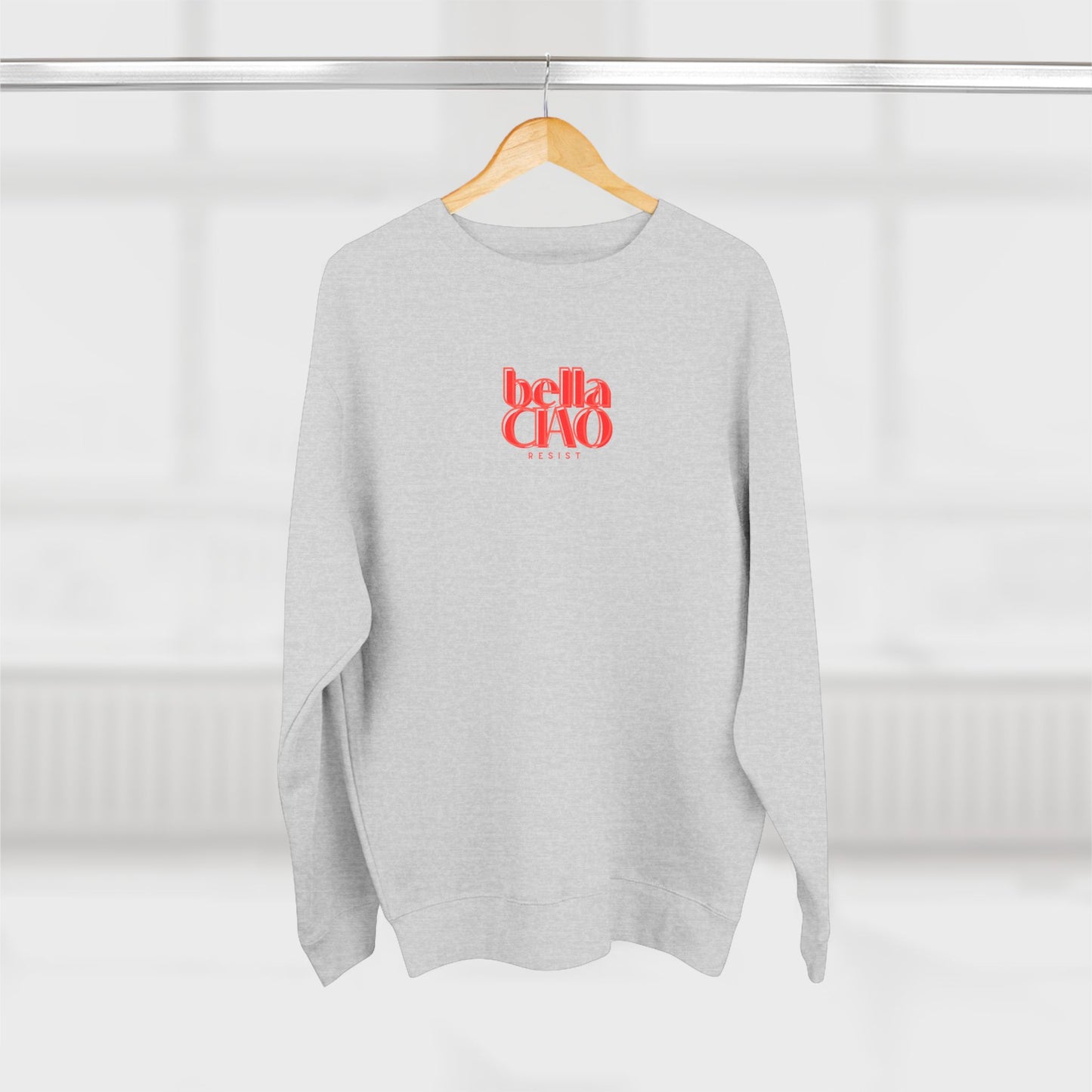 Gray sweatshirt with red 'bella CHA' text on a hanger against a white background