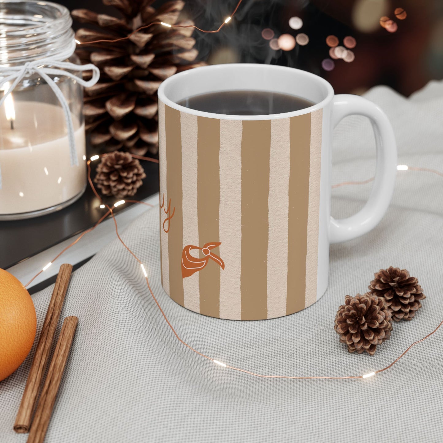 Striped mug with a logo on a table with decorative items