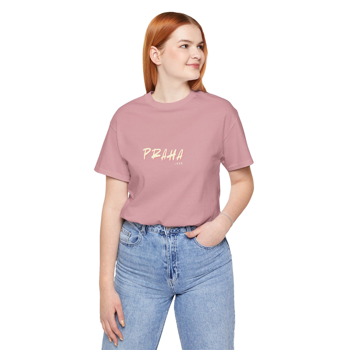 Person wearing a pink t-shirt with 'PRAHA' text and blue jeans on a white background