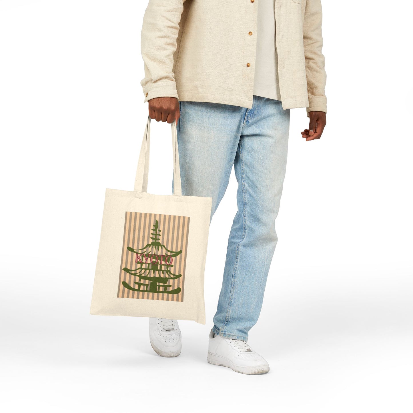 Person holding a tote bag with a design on a white background