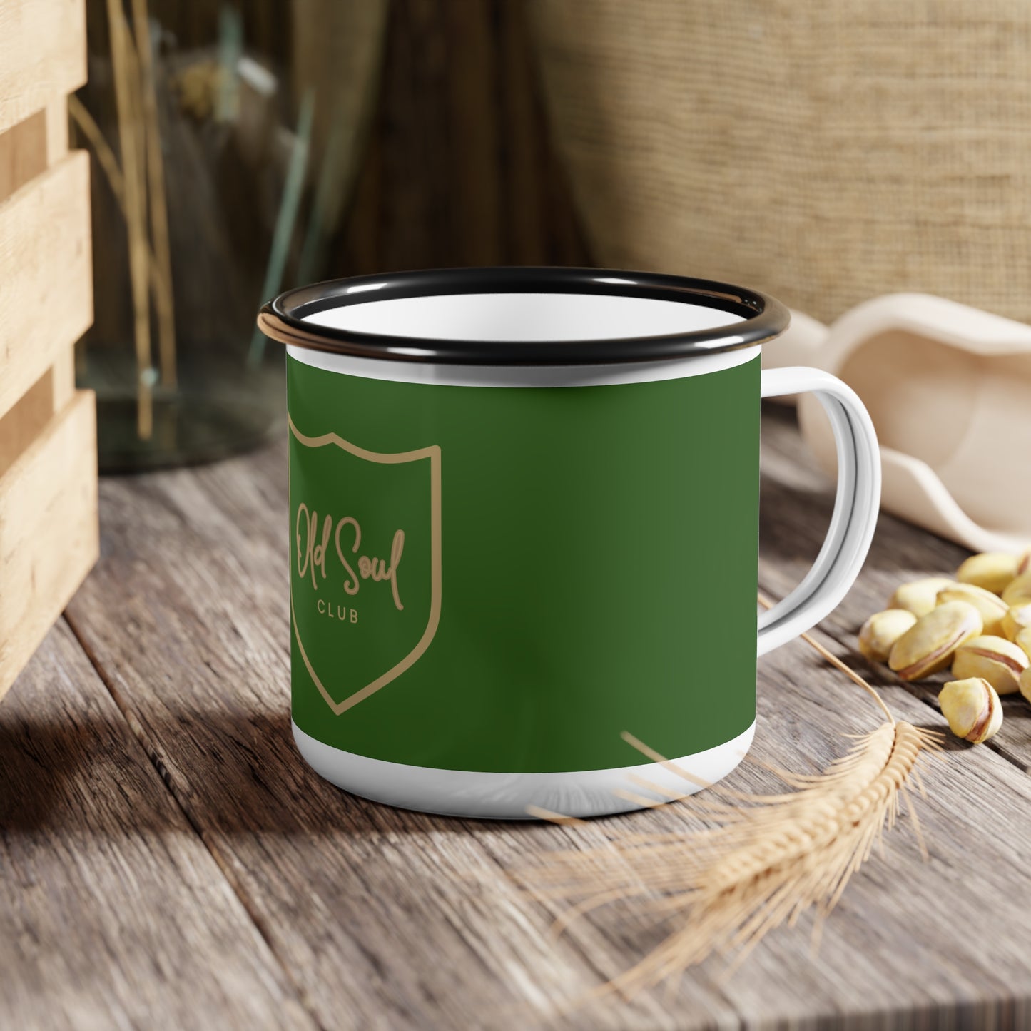 Green enamel mug with 'Old Soul Club' logo on a wooden surface
