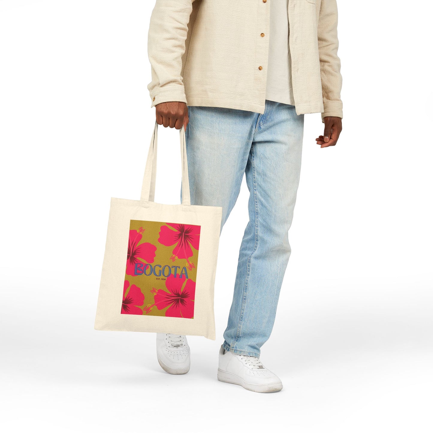 Person holding a tote bag with floral design and 'Bogota' text on a white background