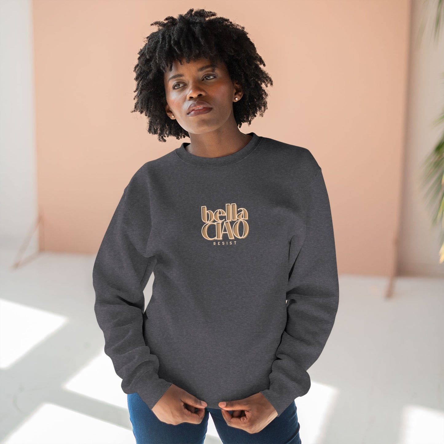 Person wearing a gray sweatshirt with 'bella CIAO' text in gold against a light background