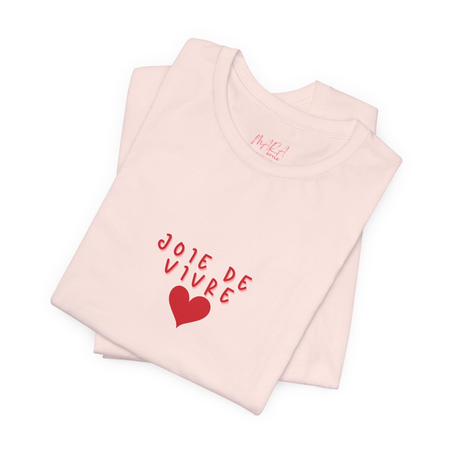 Folded pink tank top with 'JOIE DE VIVRE' text and heart design on a white background