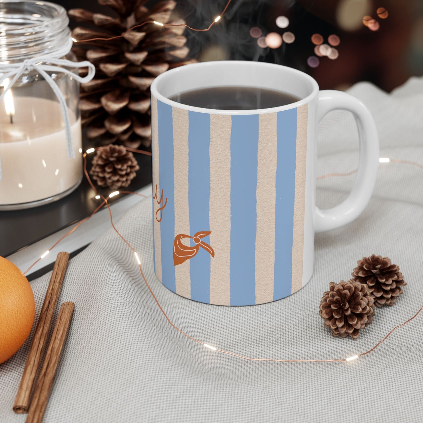 Striped mug with a design on a table with decorative items