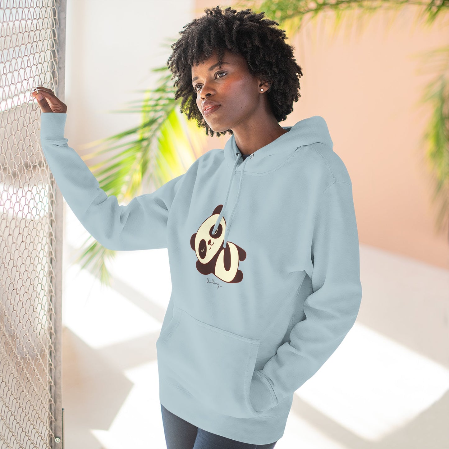 Person wearing a light blue hoodie with a panda design, standing against a neutral background.