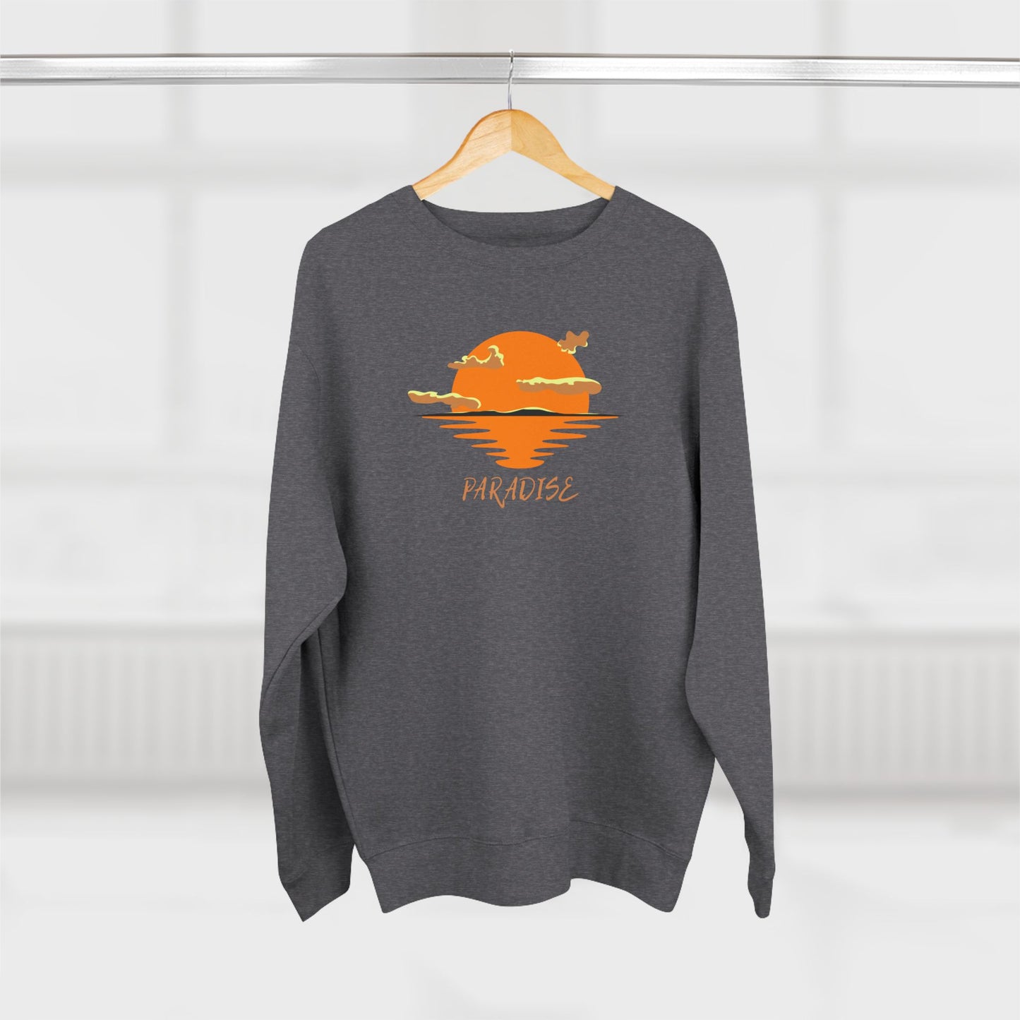 Gray sweatshirt with a sunset design and 'Paradise' text on a hanger against a white background