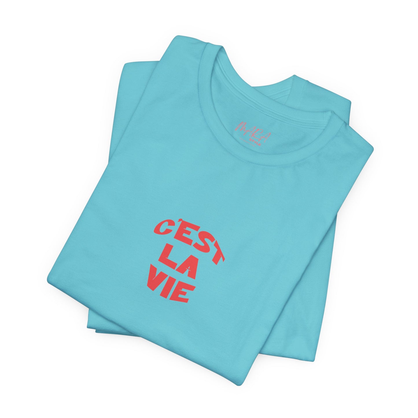 Folded light blue t-shirt with red text 'Cést La Vie' on a white background