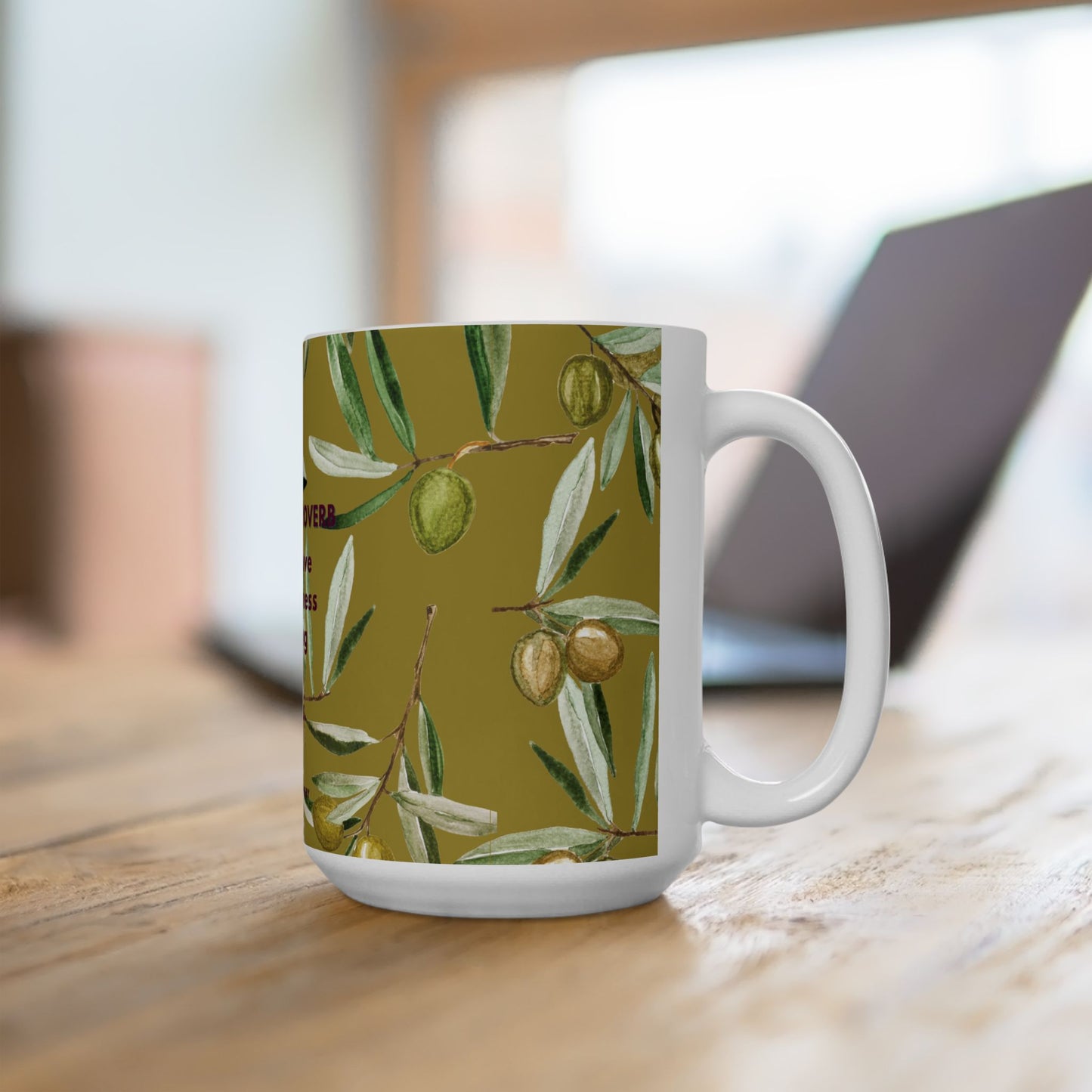 White mug with olive branch pattern on a wooden surface