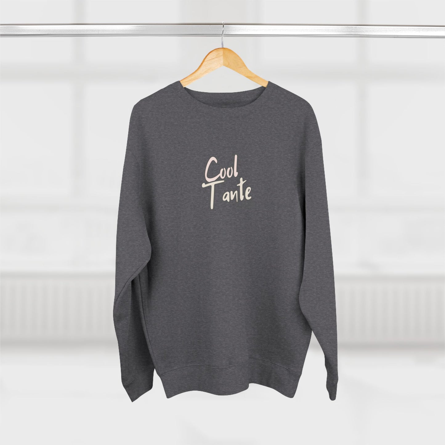 Gray sweatshirt with 'Cool Tante' text on a wooden hanger against a white background