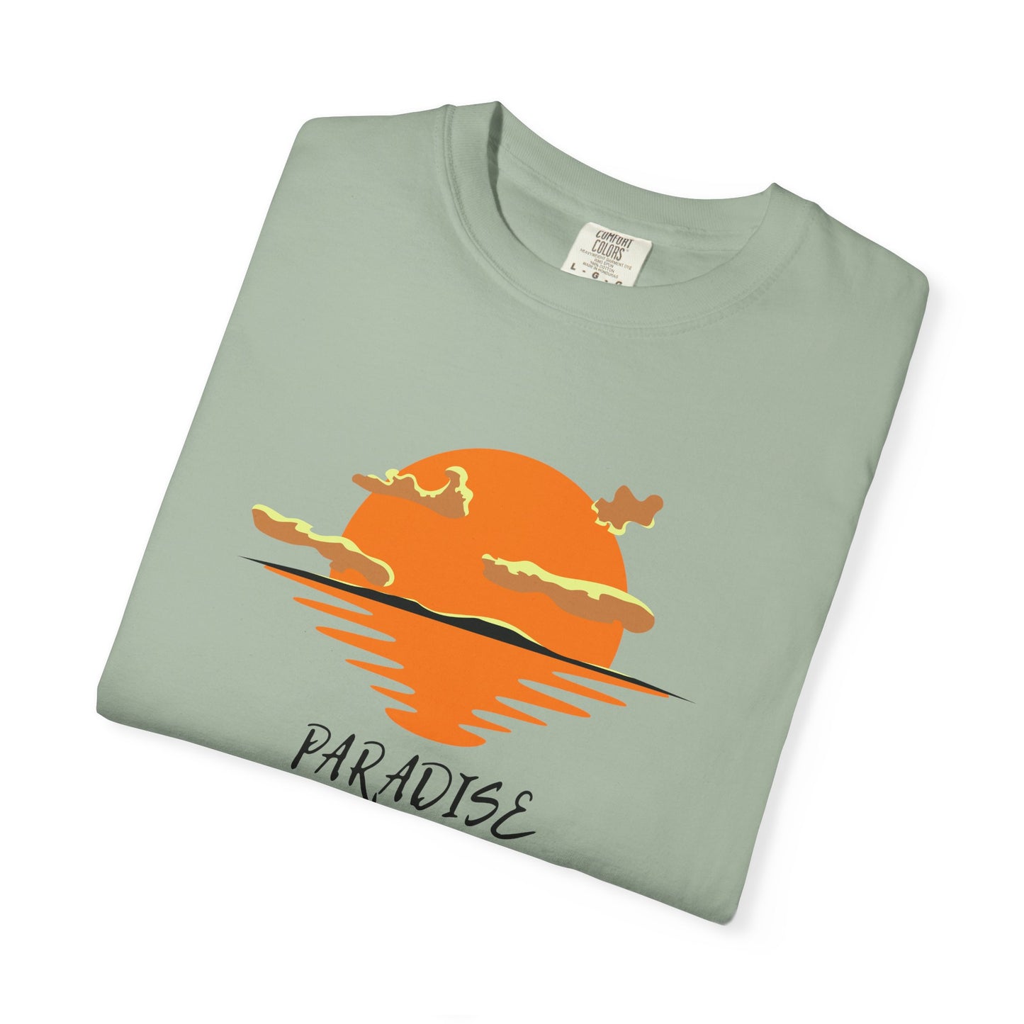Folded light green t-shirt with orange sunset graphic and 'Paradise' text on a white background