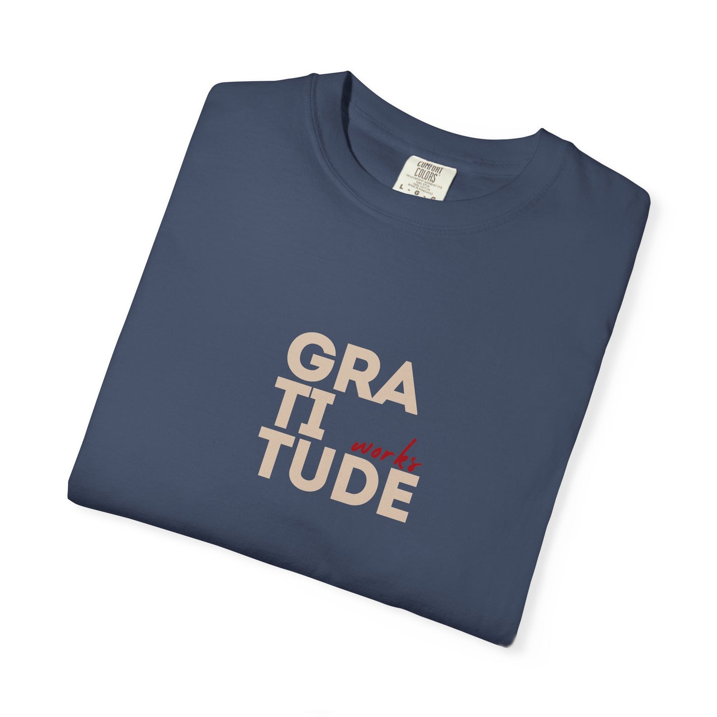 Folded navy blue t-shirt with 'GRATITUDE' text on a white background