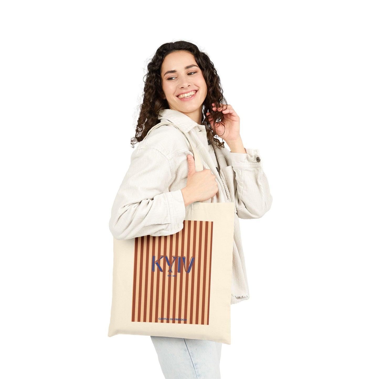 Woman holding a tote bag with 'KYIV' printed on it against a white background