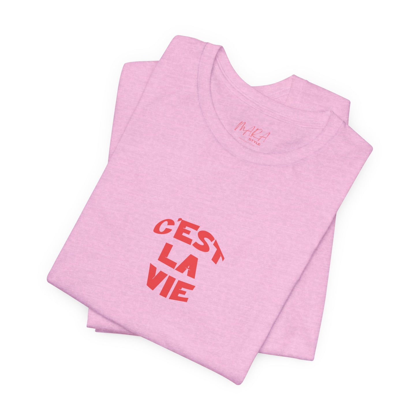 Folded pink t-shirt with 'C'EST LA VIE' text on a white background