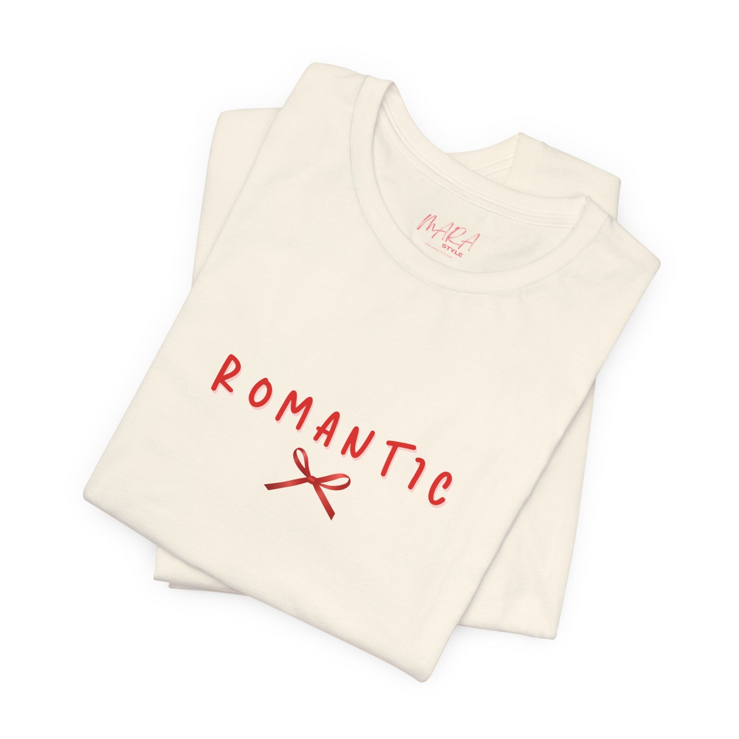 Folded cream-colored tank top with 'ROMANTIC' and a bow graphic in red on a white background.