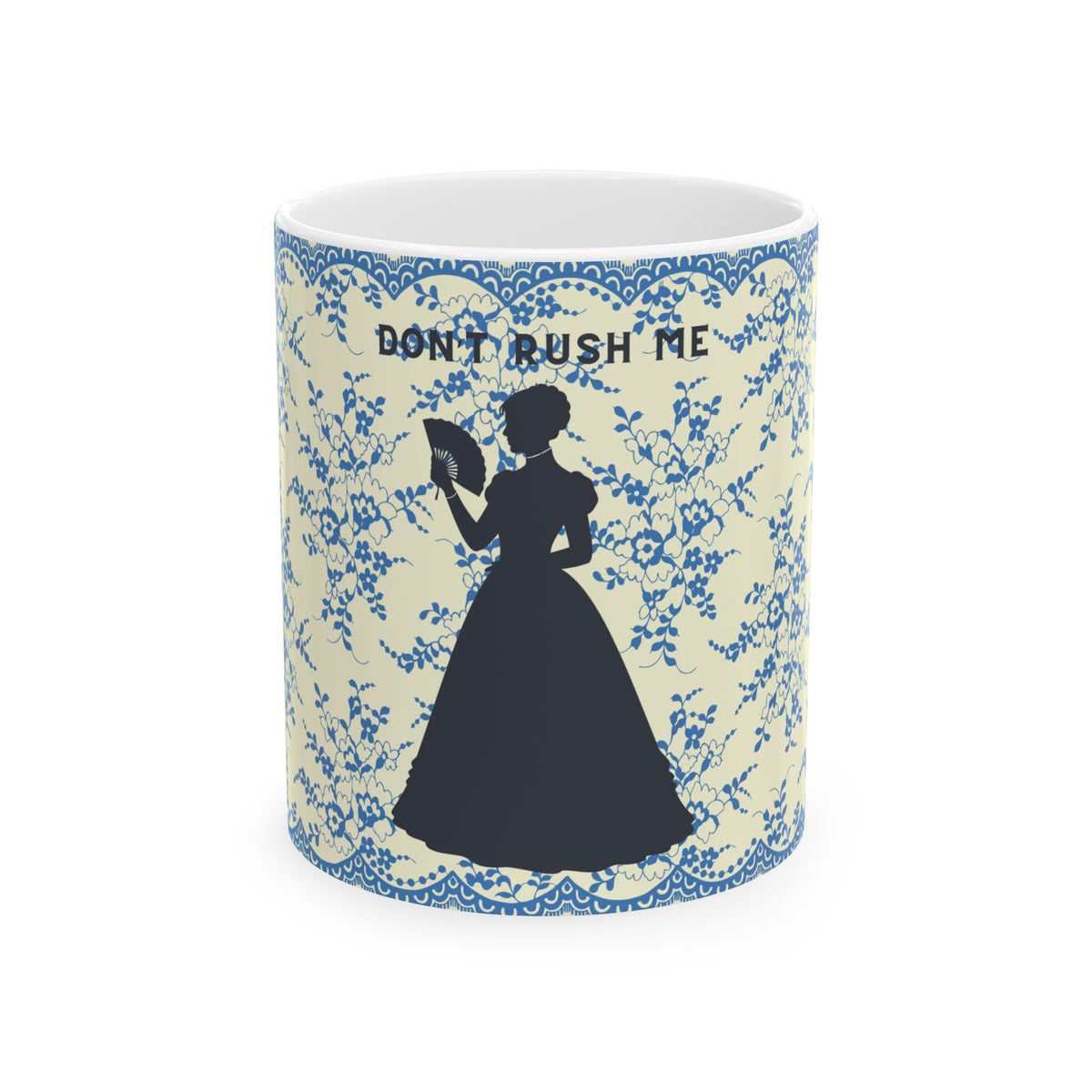 A white ceramic mug featuring a blue floral pattern border, a black silhouette of a woman in a long dress holding a fan, and the text 'DON'T RUSH ME' printed above the figure, shown on a plain white background.