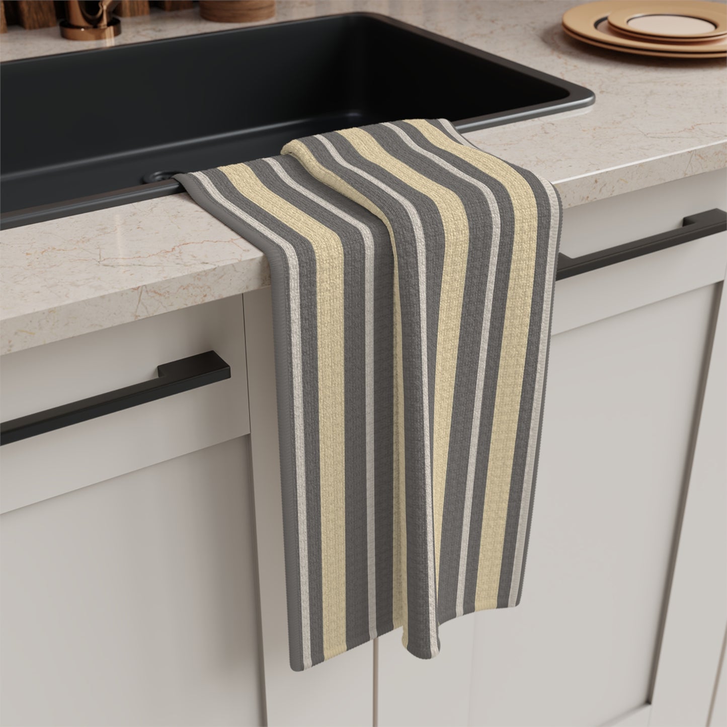 Striped kitchen towel hanging over a kitchen counter with a sink in the background