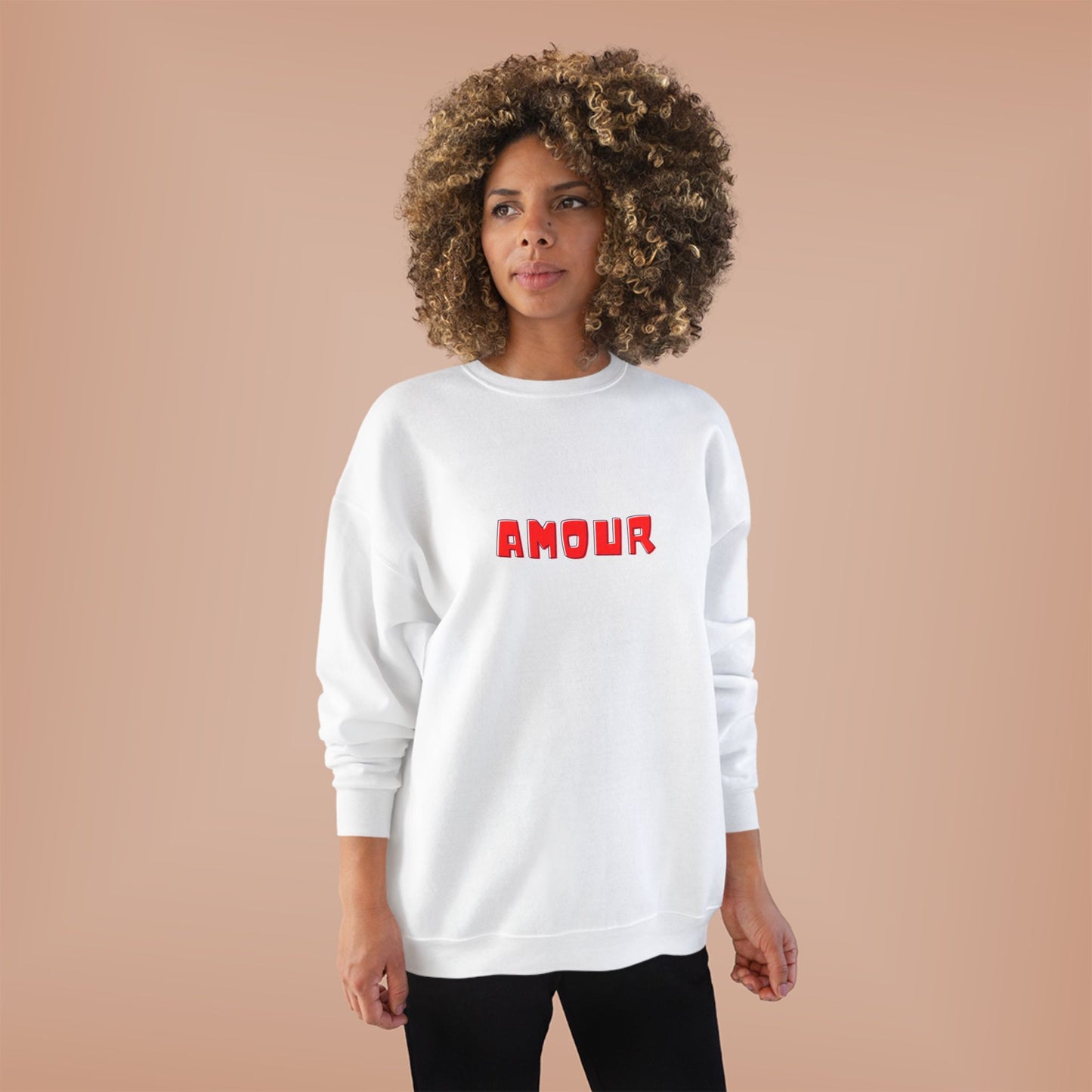 Person wearing a white sweatshirt with 'AMOUR' printed in red on a beige background