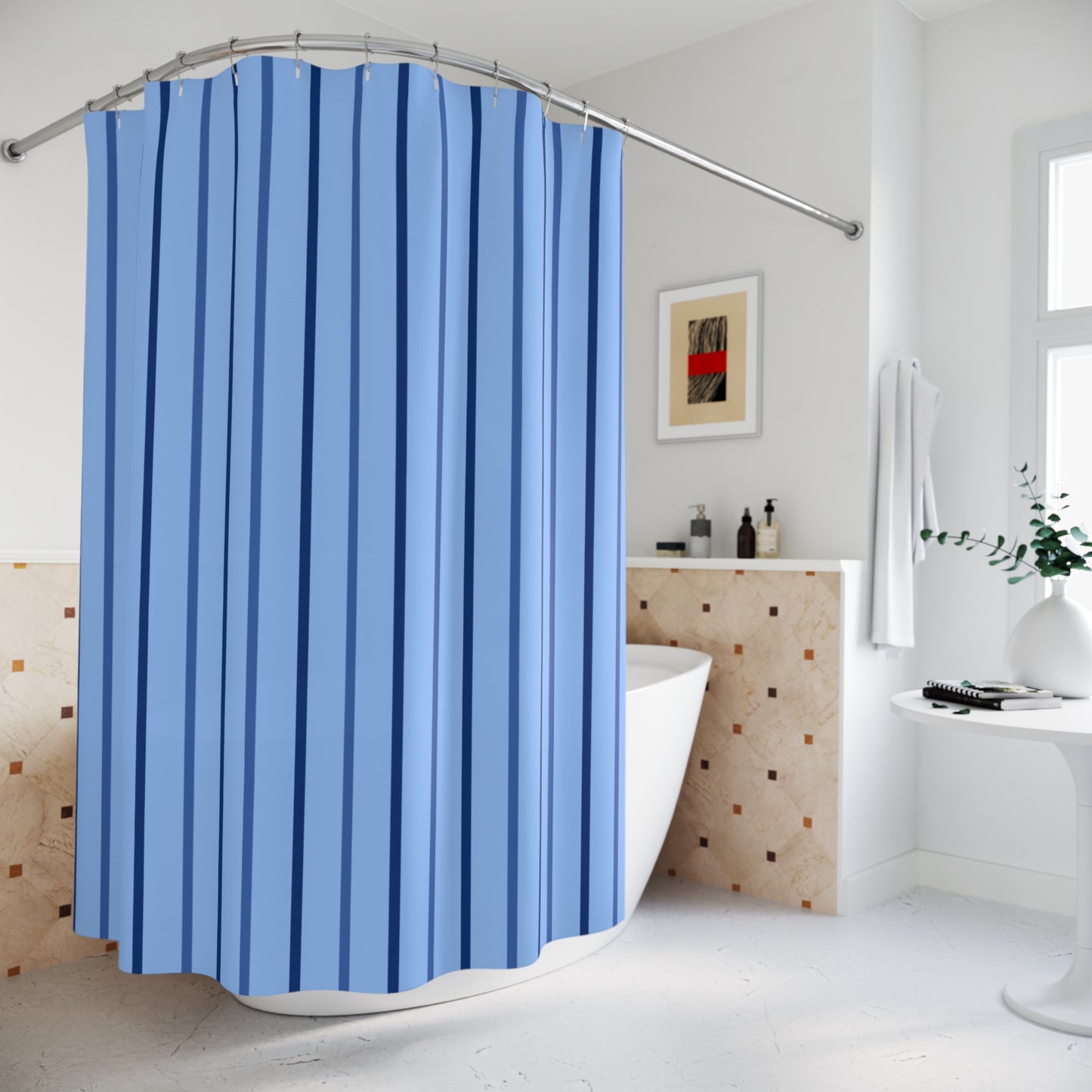 A blue shower curtain with vertical stripes hanging in a bright, modern bathroom with a white bathtub, tiled wall, and white pedestal table.
