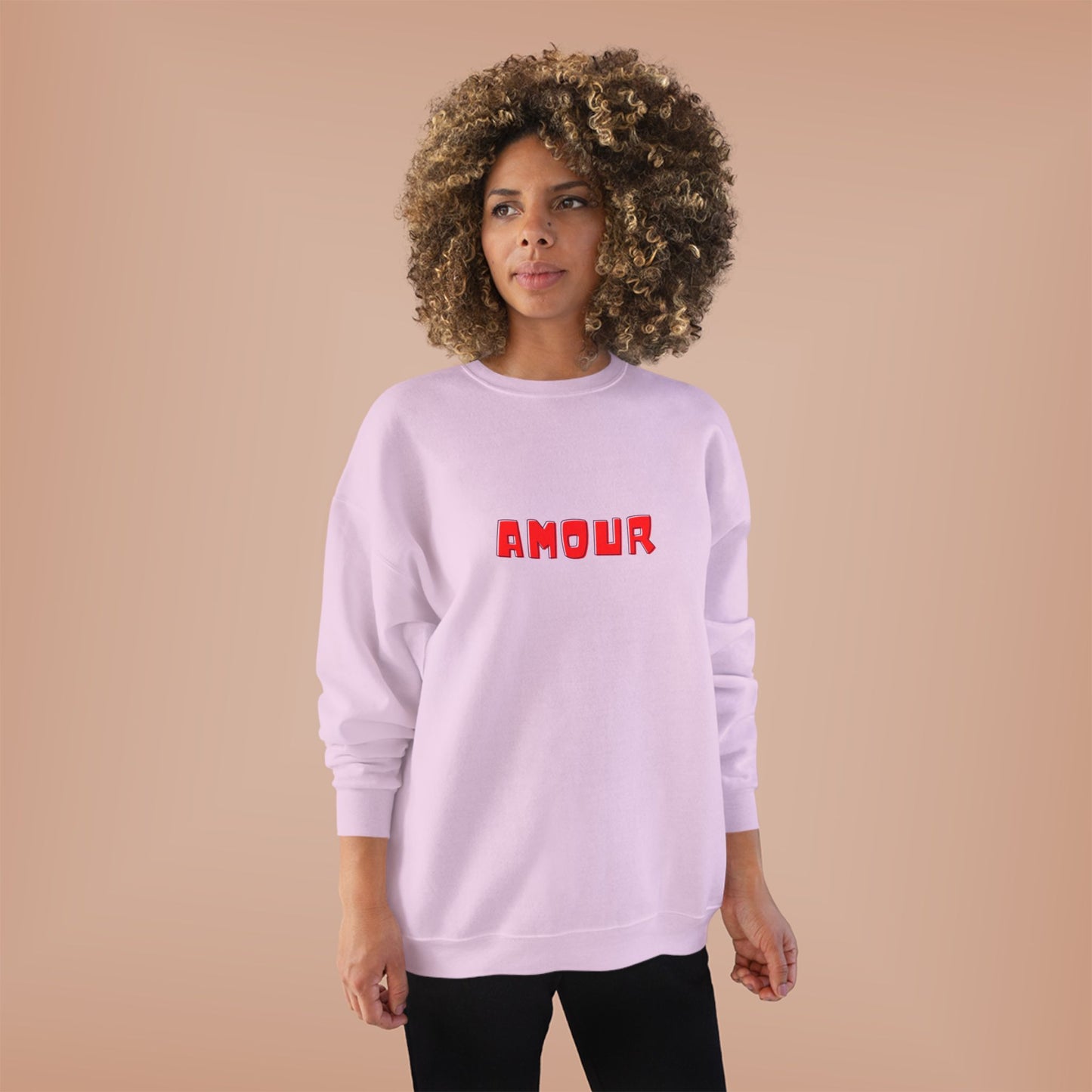 Person wearing a light purple sweatshirt with 'AMOUR' printed in red on a beige background