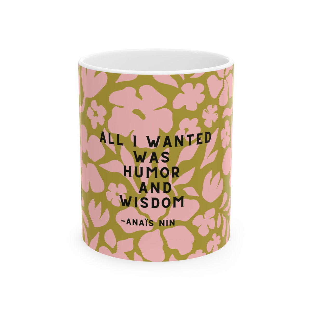 A white ceramic mug featuring a pink and olive green floral pattern with the quote 'ALL I WANTED WAS HUMOR AND WISDOM -ANAIS NIN' printed in black text.